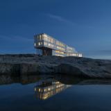 Das Fogo Island Inn ist zu sehen, mit erleuchteten Fenstern bei Nacht